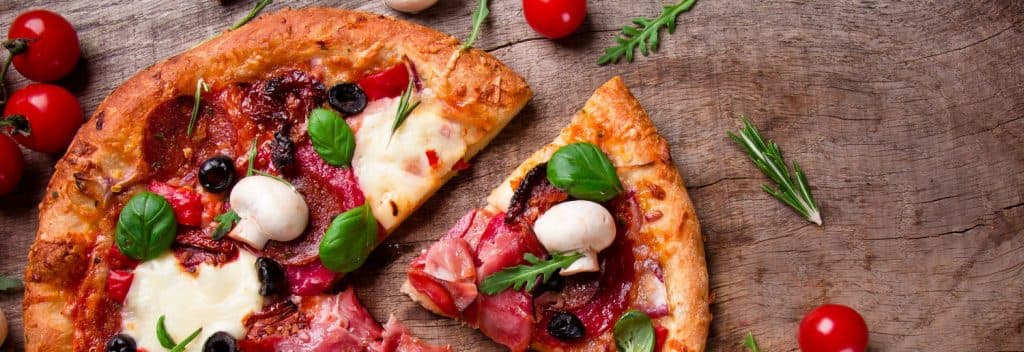 Wide landscape format pizza image with toppings and golden baked crust